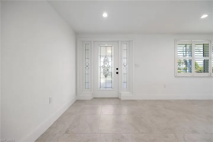 Bright and welcoming entry featuring elegant glass panel door with side panels