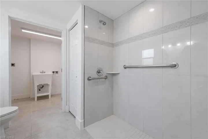 Bathroom with a tile shower and light tile patterned floors