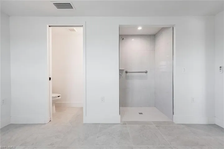 Guest bedroom ensuite with walk-in shower, separate toilet, and vanity area.