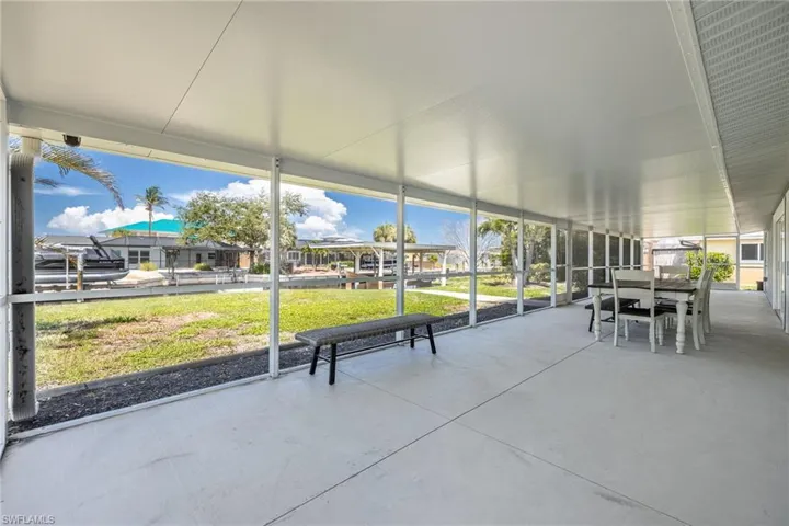 Screened covered lanai with water views, ideal for outdoor dining and relaxation.
