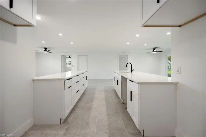 Kitchen featuring ceiling fan, white cabinetry, a peninsula, and recessed lighting
