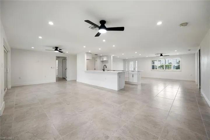 Unfurnished living room with a ceiling fan and recessed lighting