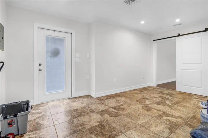 Guest House: featuring a barn door, tile floors, and ornamental molding