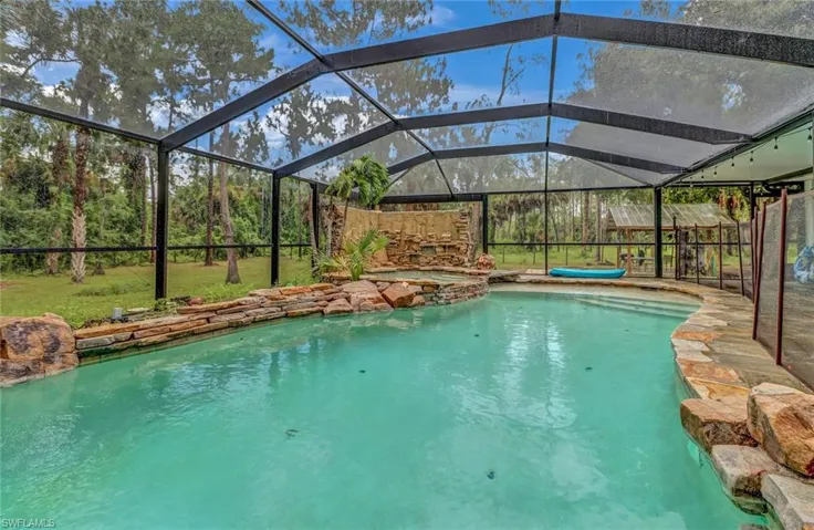 View of swimming pool featuring screened enclosure