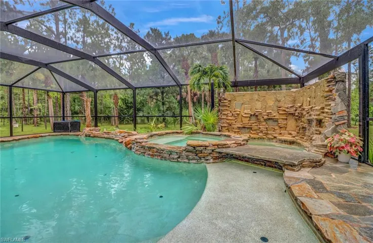 View of pool with an in ground hot tub and a lanai
