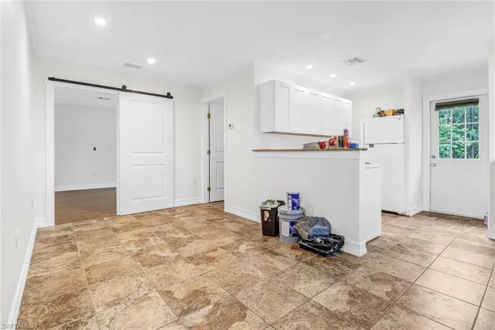 Guest house living area  featuring a barn door and light tile flooring