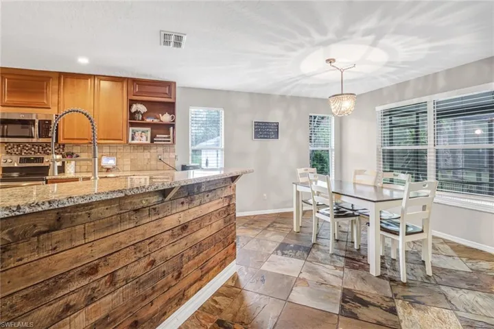 Tiled dining space featuring plenty of natural light and a chandelier