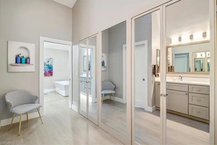 Full bath featuring light wood finished floors, vanity, and a freestanding tub