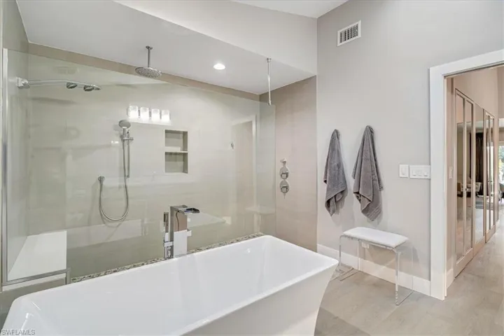 Bathroom featuring a freestanding bath, a stall shower, recessed lighting, and wood finished floors