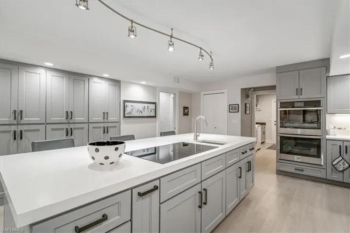 Kitchen featuring gray cabinetry, double oven, recessed lighting, black electric stovetop, and light wood-style flooring