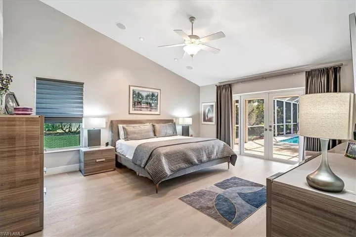 Bedroom with french doors, light wood-style floors, high vaulted ceiling, access to outside, and ceiling fan
