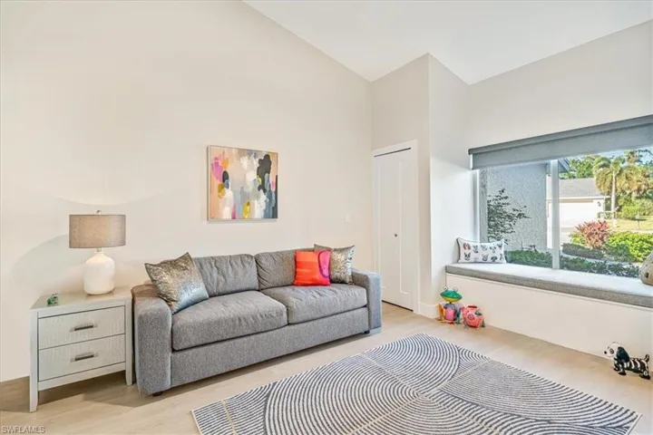 Living room with wood finished floors and high vaulted ceiling