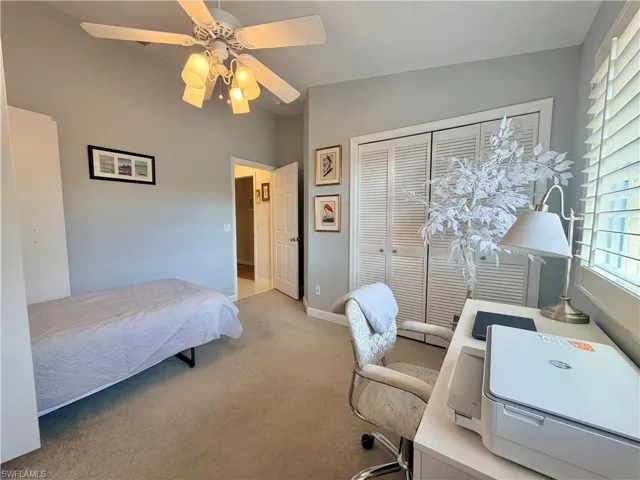 Bedroom featuring a desk, carpet flooring, a ceiling fan, and a closet