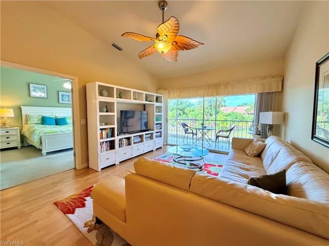 Living area featuring lofted ceiling, light wood-type flooring, and a ceiling fan