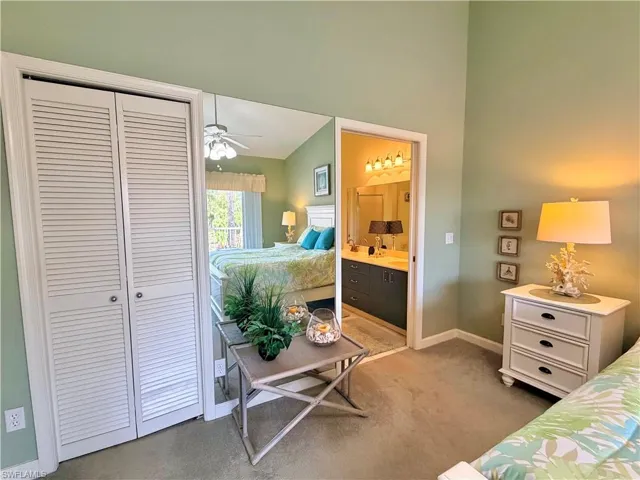 Bedroom with vaulted ceiling, ensuite bath, a closet, and a ceiling fan