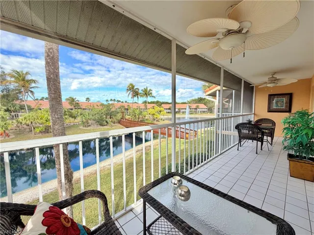 Balcony featuring a ceiling fan, a water view, and outdoor dining space