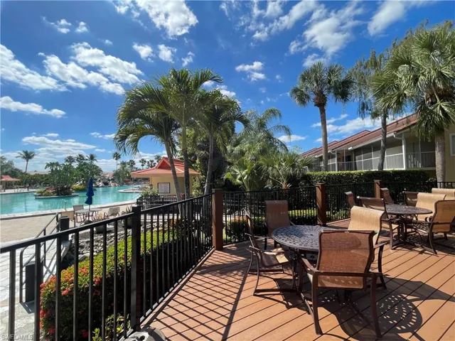 Deck with outdoor dining space, a water view, and a community pool