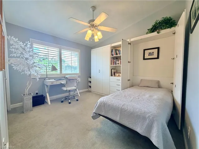 Bedroom featuring lofted ceiling, a ceiling fan, a desk, and light colored carpet