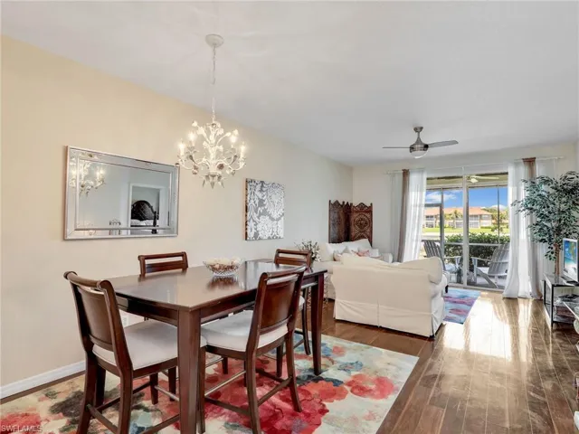 Dining space featuring wood finished floors, a chandelier, and a ceiling fan