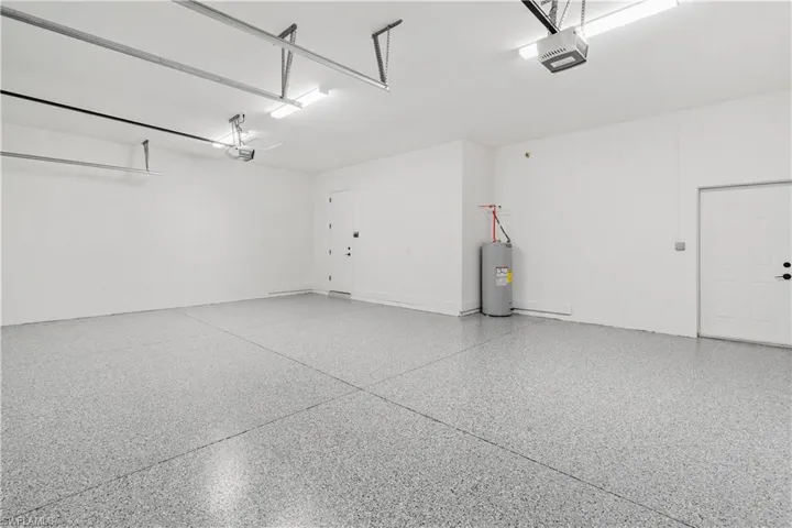 Garage featuring a garage door opener and water heater