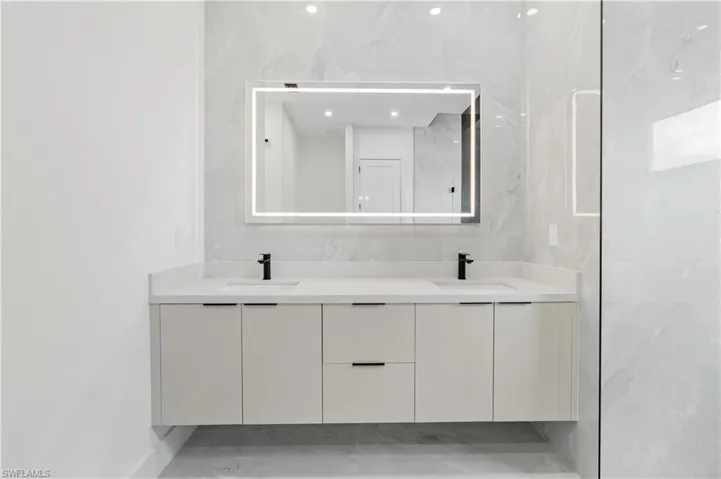 Bathroom featuring dual vanity, tile walls, and tile patterned floors