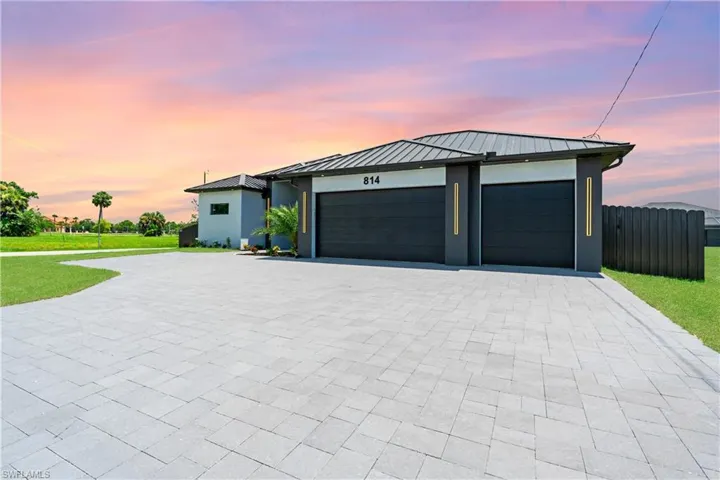 View of front of property with a garage and a lawn