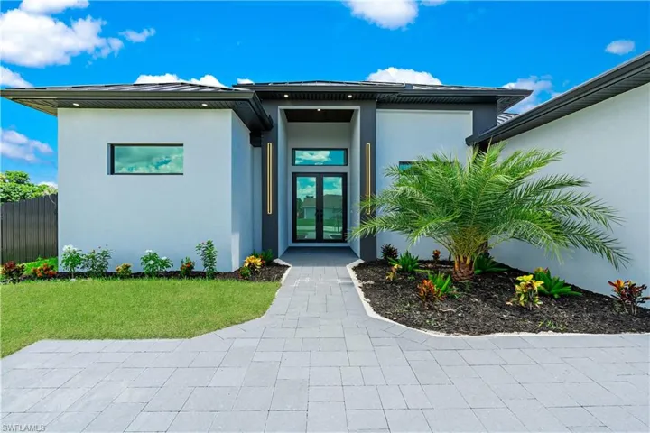 Property entrance featuring french doors and a lawn