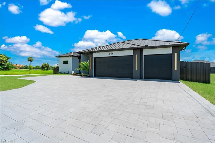 View of front of property featuring a garage and a front yard