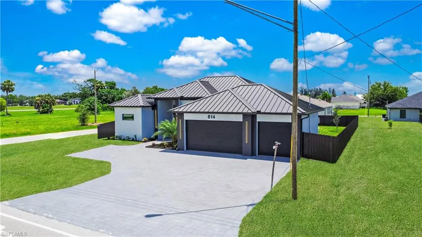 View of front of home with a garage and a front lawn