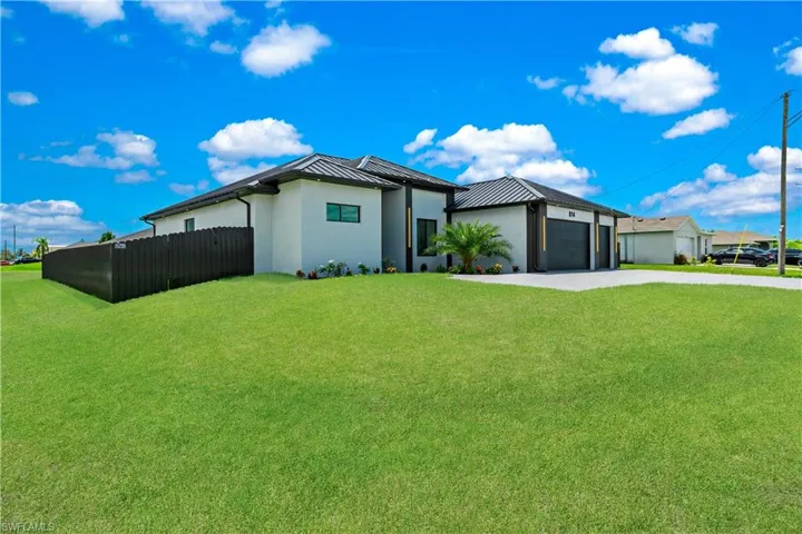 View of front of property with a garage and a front lawn