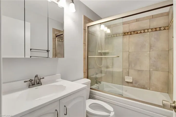 Guest Bathroom with vanity and combined bath / shower with glass slider door.