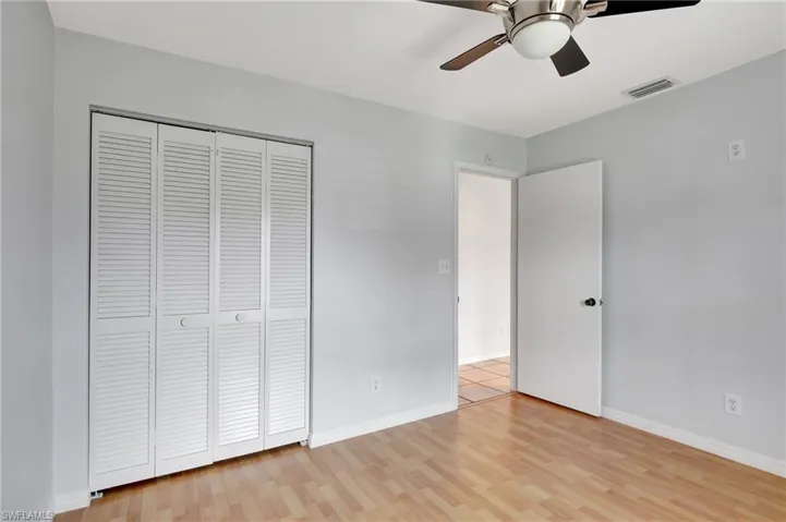 Unfurnished bedroom featuring a ceiling fan, light wood finished floors, and a closet.
