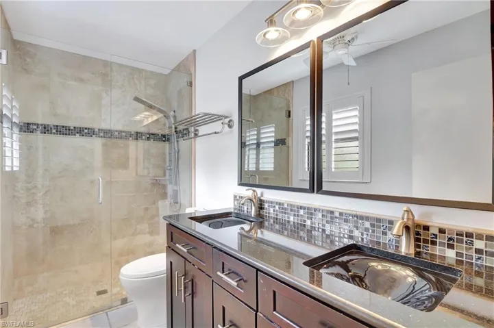 Master Bathroom with double vanity, a stall shower, light tile patterned floors, and a ceiling fan