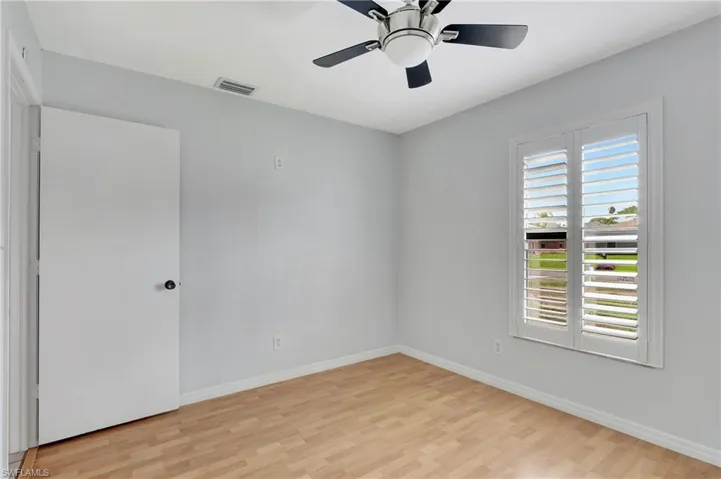 Guest room featuring light wood-type flooring and a ceiling fan.