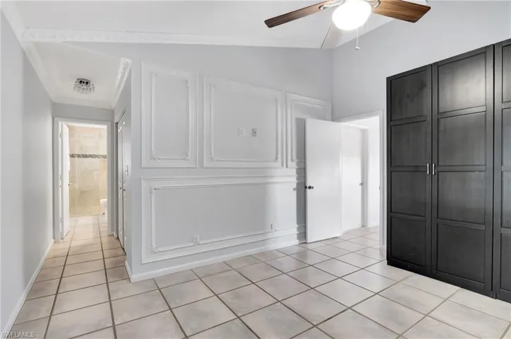 Master bedroom  featuring light tile patterned flooring, lofted ceiling, and a ceiling fan