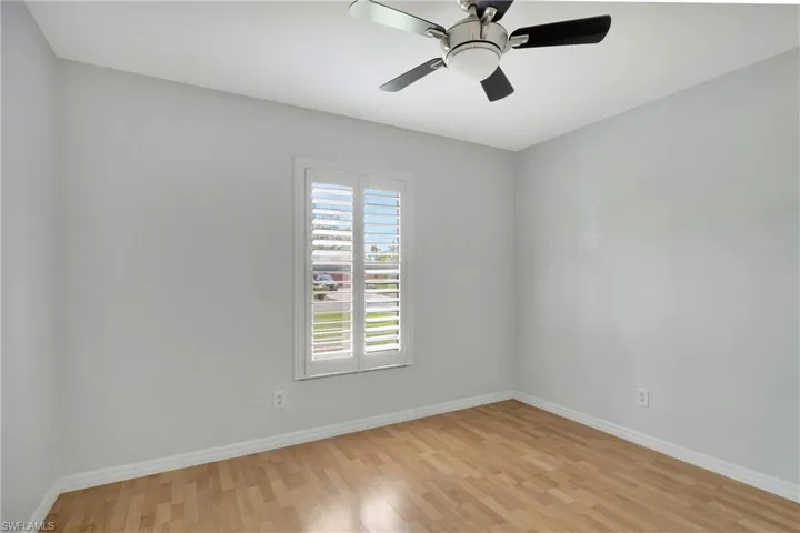 Spare room with light wood-style floors and a ceiling fan.