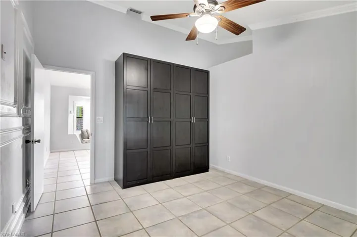 Master bedroom  featuring ornamental molding, ceiling fan, light tile patterned floors, and a closet