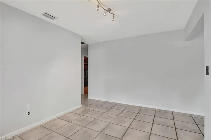 Formal dinning  room featuring light tile patterned floors and rail lighting.