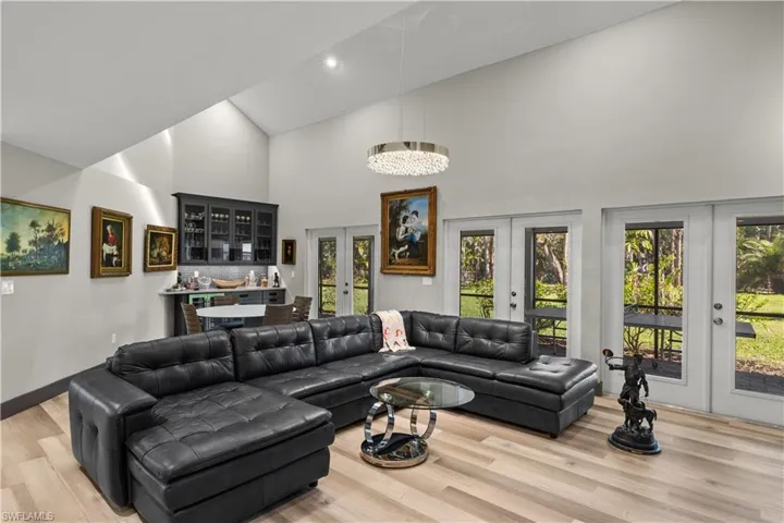 Living area with high vaulted ceiling, and french doors