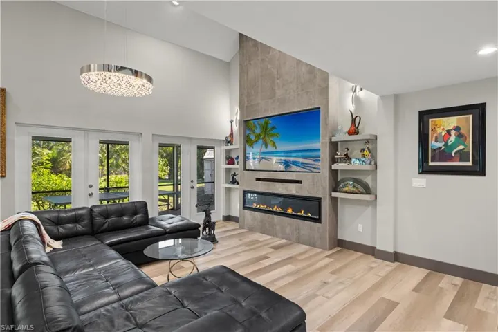 Another view of the Living room featuring a towering ceiling and an elelctirc fireplace