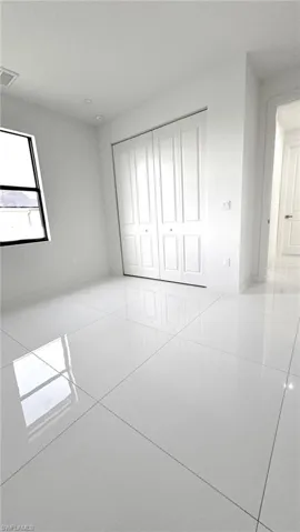 Unfurnished bedroom with a closet and light tile patterned floors