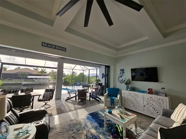 Great room featuring ceiling fan, Tray ceiling (11ft) with crown molding, and Porcelain Plank Floors, 10ft Ceiling Heights throughout, 24ft Pocketing Sliding Glass Doors to Lanai.