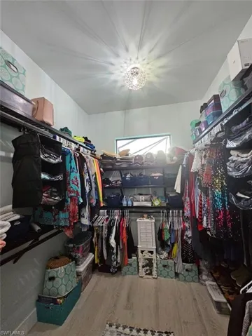 Walk in closet with Porcelain Plank Floors, Transom window for natural light.