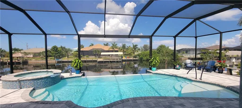 View of 1200 sqft paver pool deck, 14'x28' Heated Infinity Saltwater Pool, 18" raised Heated Spa and Picture View Screen.