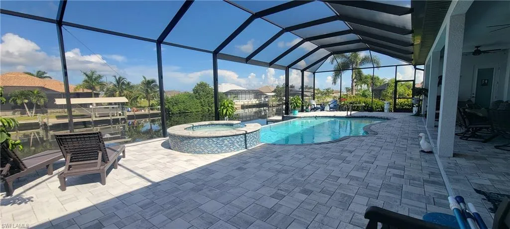 View of 1200 sqft paver pool deck, 14'x28' Heated Infinity Saltwater Pool, 18" raised Heated Spa