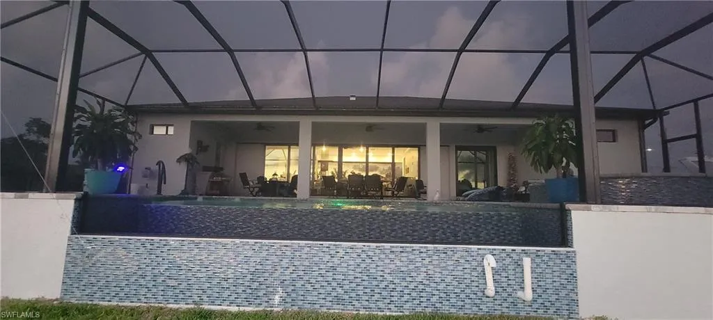 View of front of property with a patio area, glass enclosure, and ceiling fan
