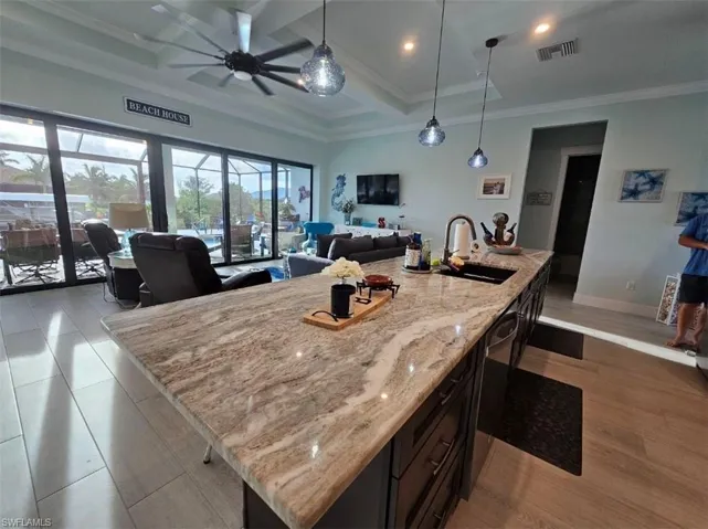 Kitchen Island-featuring a 13ft center island, ceiling fan, sink, pendant lights, extra drawer banks, trash pullout.