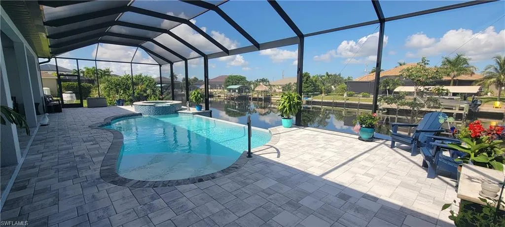 View of 1200 sqft paver pool deck, 14'x28' Heated Infinity Saltwater Pool, 18" raised Heated Spa and Picture View Screen.