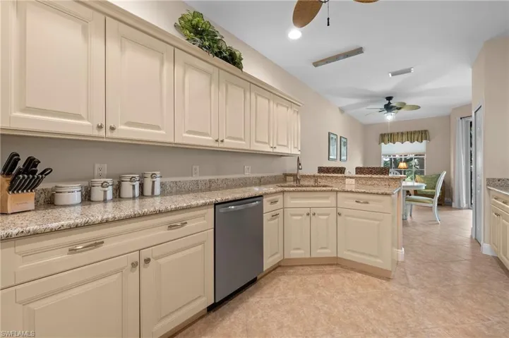 Kitchen with ceiling fan, cream cabinets, sink, and stainless steel dishwasher