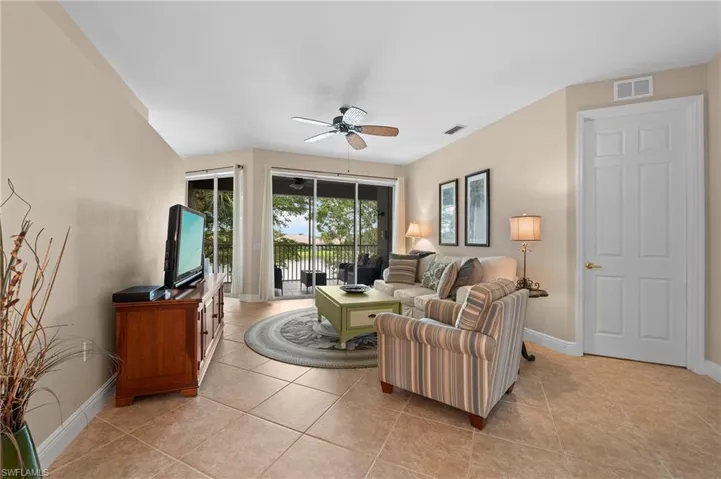 Living room with light tile patterned flooring and ceiling fan